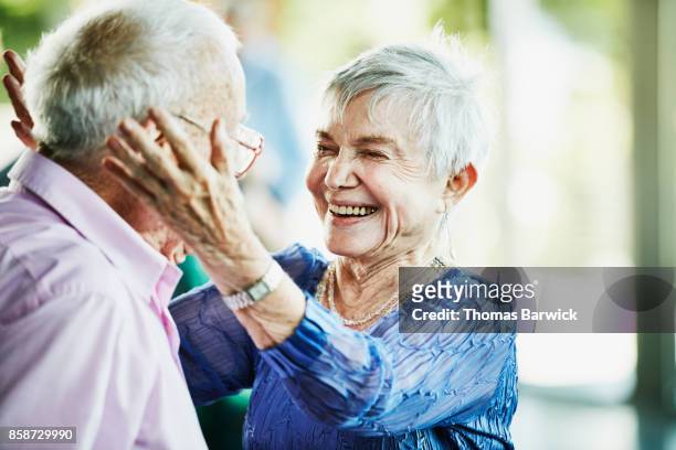 laughing senior woman embracing partner after dance in community center - body positive men stock pictures, royalty-free photos & images
