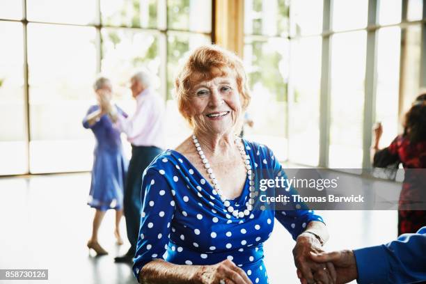 smiling senior woman dancing with husband in community center - free pictures ballroom dancing stock pictures, royalty-free photos & images