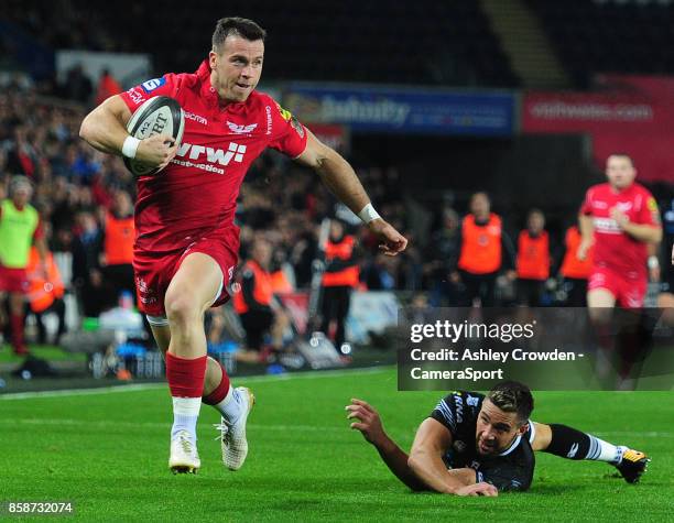 Scarlets' Gareth Davies evades the tackle of Ospreys' Rhys Webb during the Guinness Pro14 Round 6 match between Ospreys and Scarlets at Liberty...