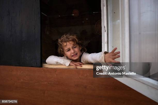 Child opens the window of their room in an occupied building on October 4, 2017 in Rome, Italy. For the last 5 years, hundreds of people, including...