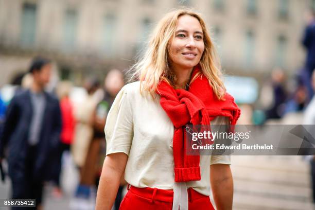 Guest wears a red scarf, a white t-shirt, red pants, outside Stella Mccartney, during Paris Fashion Week Womenswear Spring/Summer 2018, on October 2,...