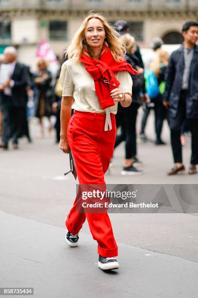 Guest wears a red scarf, a white t-shirt, red pants, outside Stella Mccartney, during Paris Fashion Week Womenswear Spring/Summer 2018, on October 2,...