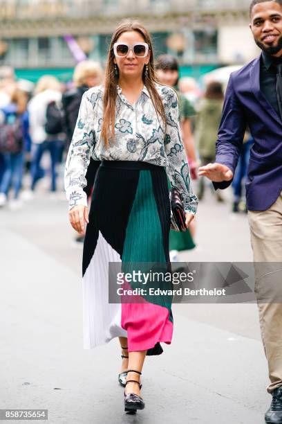 Guest wears sunglasses, a flower print shirt, a pleated color skirt, outside Stella Mccartney, during Paris Fashion Week Womenswear Spring/Summer...