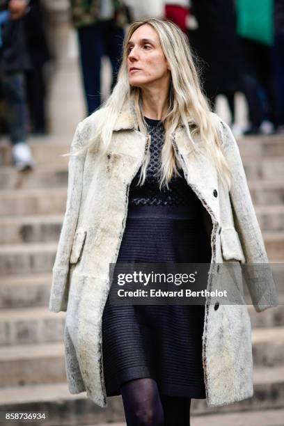 Guest wears a coat and a black dress, outside Stella Mccartney, during Paris Fashion Week Womenswear Spring/Summer 2018, on October 2, 2017 in Paris,...