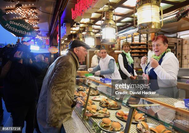 Stephan Weil , German Social Democrat and governor of the state of Lower Saxony, talks to a food vendor at a fun fair while campaigning in Lower...