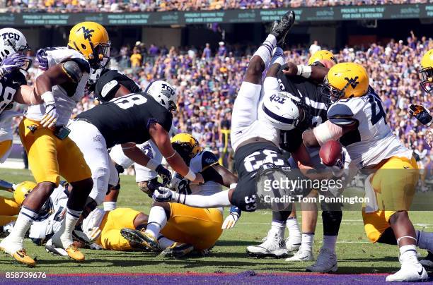Sewo Olonilua of the TCU Horned Frogs dives into the end zone to score a touchdown against the West Virginia Mountaineers in the first half at Amon...