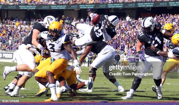 Sewo Olonilua of the TCU Horned Frogs dives into the end zone to score a touchdown against the West Virginia Mountaineers in the first half at Amon...