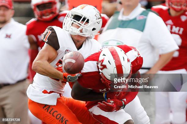 Deondre Daniels of the Miami Ohio Redhawks puts a hit on Scott Miller of the Bowling Green Falcons during the first half on October 7, 2017 in...
