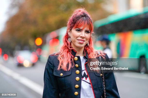 Guest wears a military jacket with golden buttons, red thigh high boots, has red pink hair, outside John Galliano, during Paris Fashion Week...