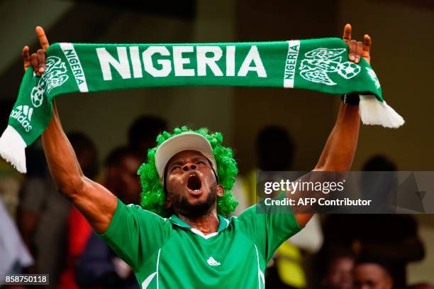 Nigerian fan waves a scarf as he celebrates after the FIFA World Cup 2018 qualifying football match between Nigeria and Zambia in Uyo, Akwa Ibom...