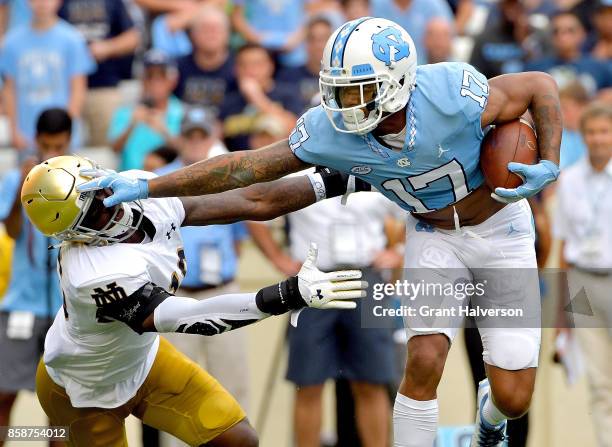 Anthony Ratliff-Williams of the North Carolina Tar Heels stiff-arms Patrick Pelini of the Notre Dame Fighting Irish during the game at Kenan Stadium...