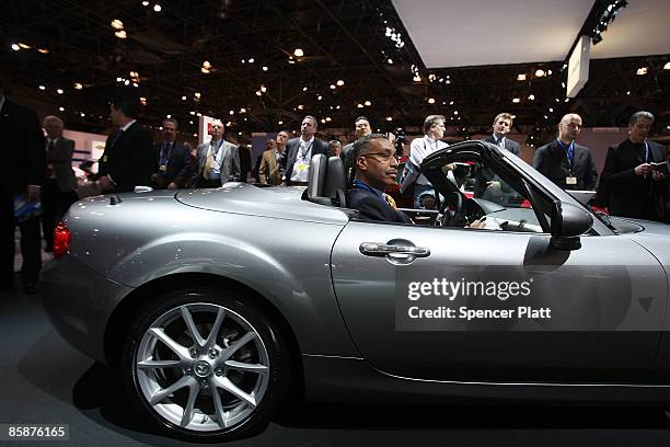Sitting in a new Mazda MX-5 Miata, attendees at the press preview for the New York Auto Show watch a presentation April 9, 2009 in New York City....