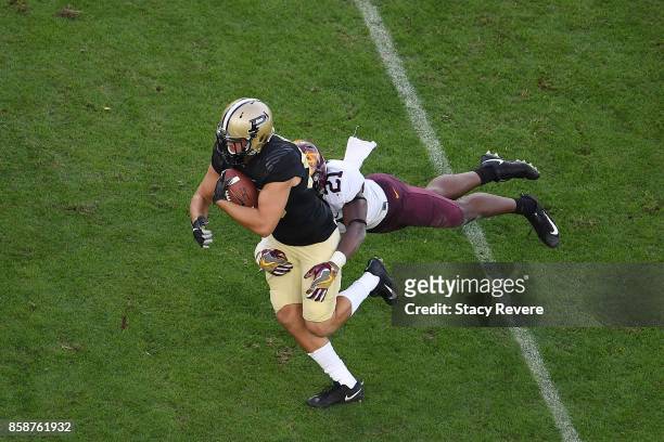 Brycen Hopkins of the Purdue Boilermakers is brought down by Kamal Martin of the Minnesota Golden Gophers during the second half of a game at...
