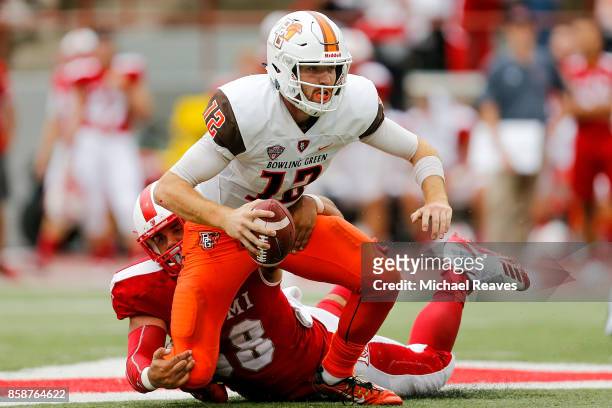 James Morgan of the Bowling Green Falcons is sacked by Doug Costin of the Miami Ohio Redhawks during the second half at Yager Stadium on October 7,...