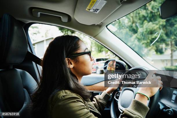 young woman sitting in drivers seat of car waiting for driving lesson - american girl alone stock-fotos und bilder