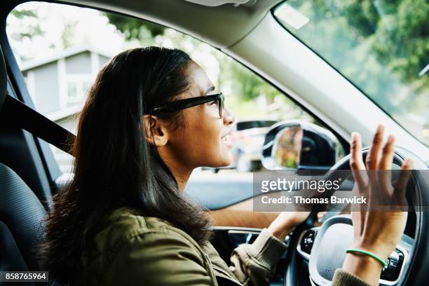 smiling young woman in drivers seat of car - girls driving a car stock pictures, royalty-free photos & images