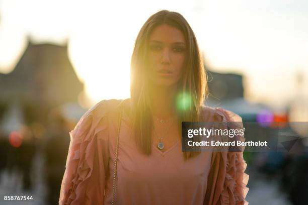 Landiana wears a pink top, purple striped shiny pants, a bag, outside Louis Vuitton, during Paris Fashion Week Womenswear Spring/Summer 2018, on...