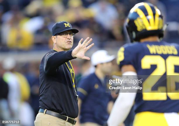 Michigan Wolverines head football coach Jim Harbaugh watches the pregame warms ups prior to the start of the game against the Michigan State Spartans...