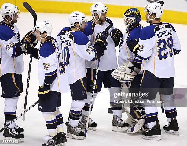 Goaltender Chris Mason of the St. Louis Blues is congratulated by teammates after defeating the Phoenix Coyotes during the NHL game at Jobing.com...