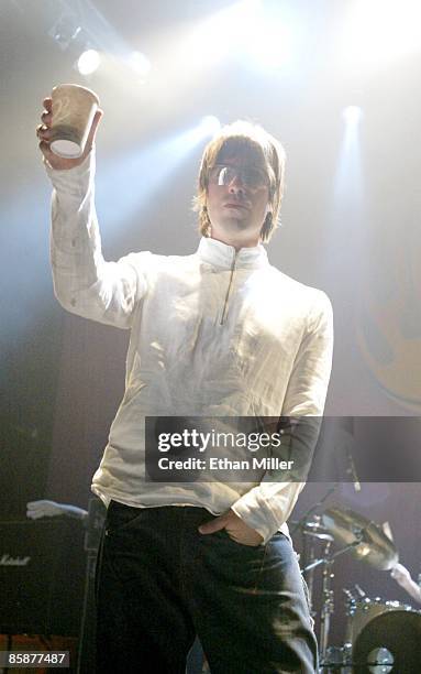 Oasis singer Liam Gallagher raises his drink to the audience during a performance at The Joint inside the Hard Rock Hotel & Casino April 26, 2002 in...
