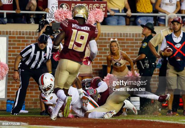 Wide receiver Darrell Langham of the Miami Hurricanes catches a pass over defensive back Tarvarus McFadden of the Florida State Seminoles for a...