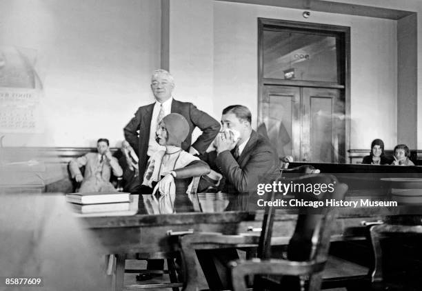 Jack McGurn, suspected killer in the St. Valentine's Day Massacre, and his sweetheart, Louise Rolfe, sitting at a table in a courtroom in Chicago,...