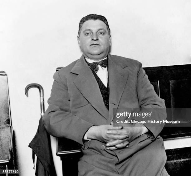 Vincent 'Jim' Genna, one of the 'terrible Genna' - a group of six brothers, looks toward the camera, as he sits on a bench in a room in Chicago,...
