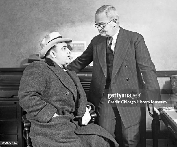 Photo of gangster Al Capone around the time of his sentencing, Chicago, 1931. He is seated facing Captain John Stege of the Chicago Police Department.