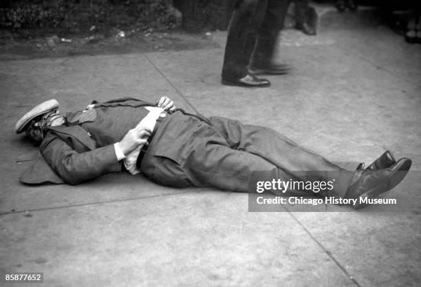 Body, possibly that of Earl 'Hymie' Weiss, lies on the sidewalk, after being gunned down by Capone's gang on State Street, October 1926. In the...