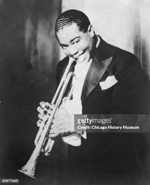 Portrait of jazz great Louis Armstrong smiling while holding his trumpet, Chicago, ca.1920s.