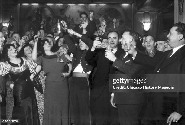 View of men and women celebrating the repeal of Prohibition with a toast and bell-ringing, Chicago, December 1933.