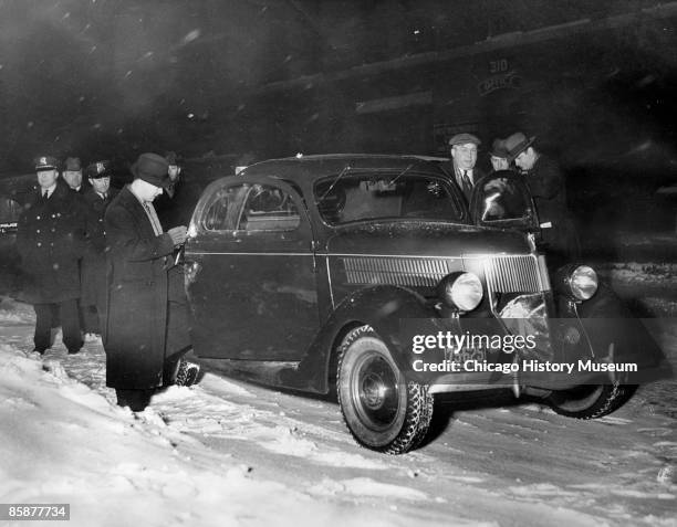 Chicago police search through Jack McGurn's car for any clues to his murder in a bowling alley at 805 Milwaukee Avenue, Chicago, 1936.