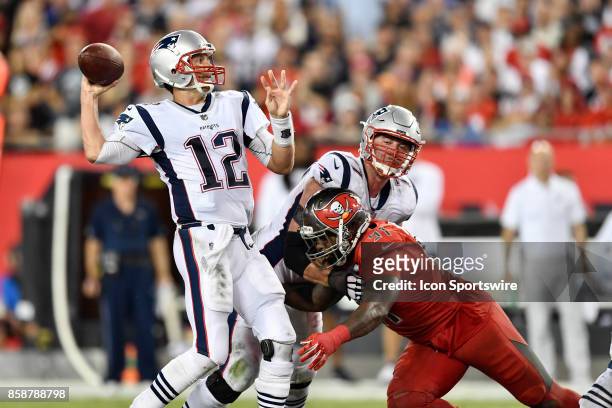 New England Patriots quarterback Tom Brady throws a pass while under pressure from Tampa Bay Buccaneers defensive end Robert Ayers Jr. During an NFL...
