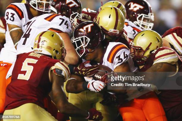 Travon McMillian of the Virginia Tech Hokies loses his helmet as he is tackled by the Boston College Eagles defense during the first half at Alumni...
