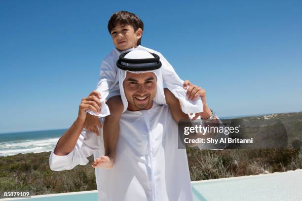 arab boy sitting on father's shoulders. - arab villa stockfoto's en -beelden