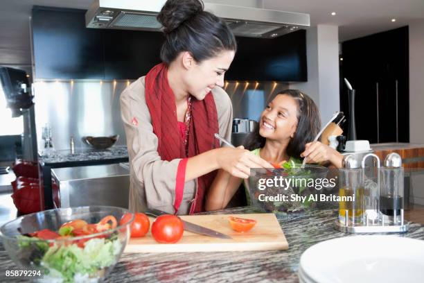 mother with daughter mixing salad in bowl. - jalabib imagens e fotografias de stock