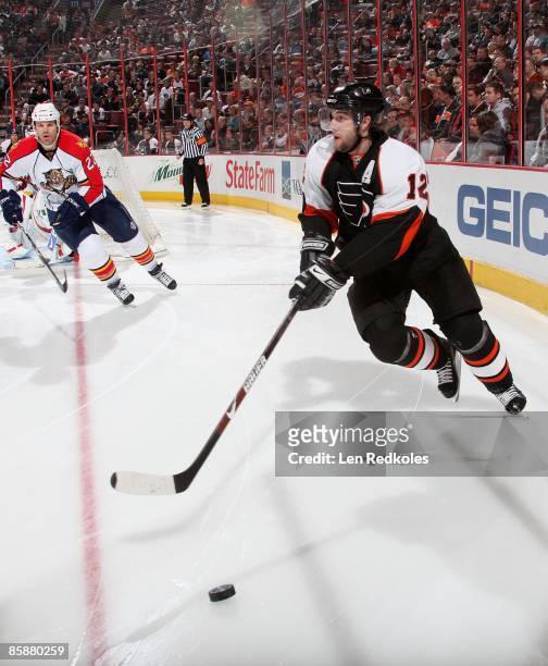 Simon Gagne of the Philadelphia Flyers skates the puck past Jassen Cullimore of the Florida Panthers on April 7, 2009 at the Wachovia Center in...