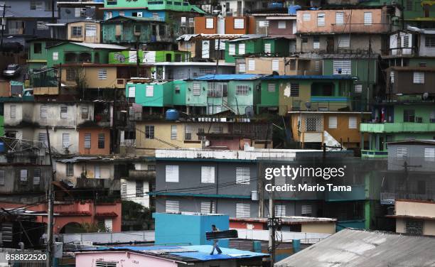 Man works repairing his damaged roof more than two weeks after Hurricane Maria hit the island, on October 7, 2017 in Naranjito, Puerto Rico. Roof...