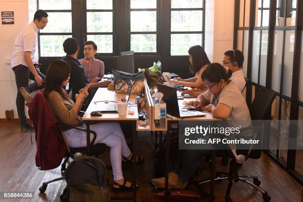 This picture taken on September 12, 2017 shows entrepreneurs working at the EV-Hive event space, a co-working space, in Jakarta. Big-name investors...