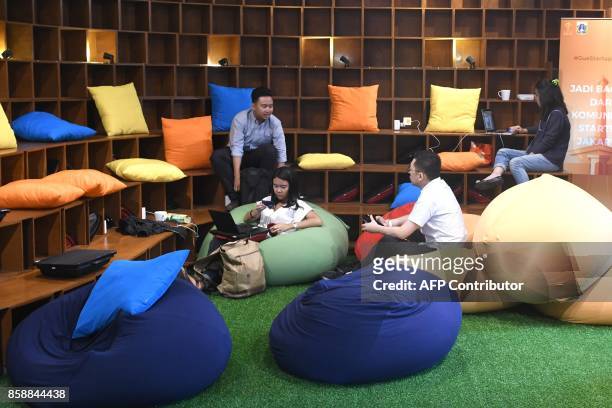 This picture taken on September 12, 2017 shows entrepreneurs working at the EV-Hive event space, a co-working space, in Jakarta. Big-name investors...
