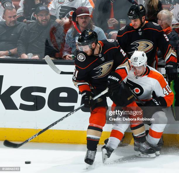 Chris Wagner and Kevin Bieksa of the Anaheim Ducks battle for the puck against Jordan Weal of the Philadelphia Flyers during the game on October 7,...