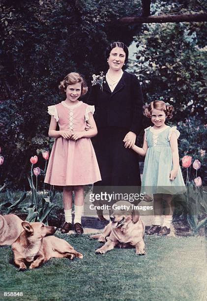 Britain's Queen Elizabeth, center, poses with her two daughters, Princess Elizabeth, left, and Princess Margaret, in June 1936 in the garden of the...
