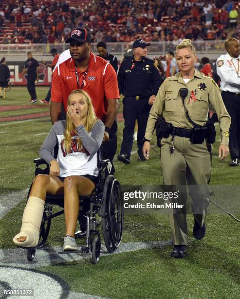 William St. Clair wheels Addison Short, who was injured in Sunday's mass shooting, off the field during a pregame ceremony as her mother, Las Vegas...