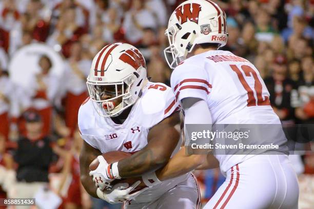 Quarterback Alex Hornibrook of the Wisconsin Badgers hands off to running back Chris James against the Wisconsin Badgers at Memorial Stadium on...