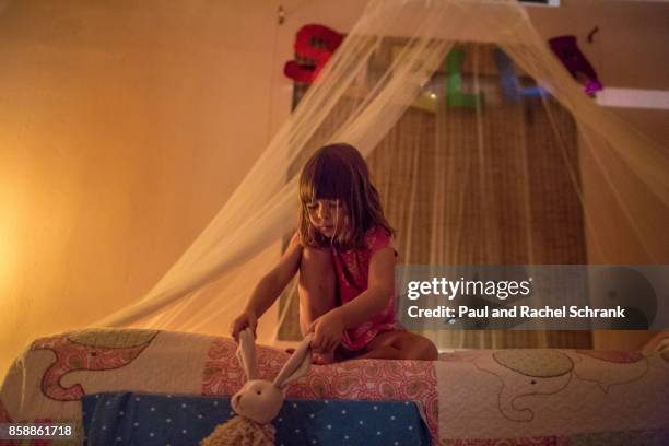 little girl holding stuffed toy, rabbit, in pink bedroom, bedtime - schrank stock pictures, royalty-free photos & images