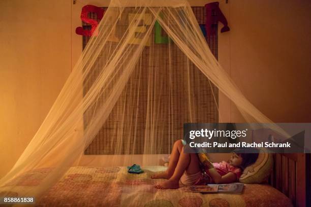 little girl reading book, in pink bedroom, bedtime - schrank stock pictures, royalty-free photos & images