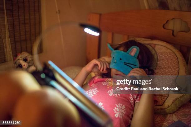 little girl with book, wearing blue bunny mask, in pink bedroom, bedtime - schrank stock pictures, royalty-free photos & images