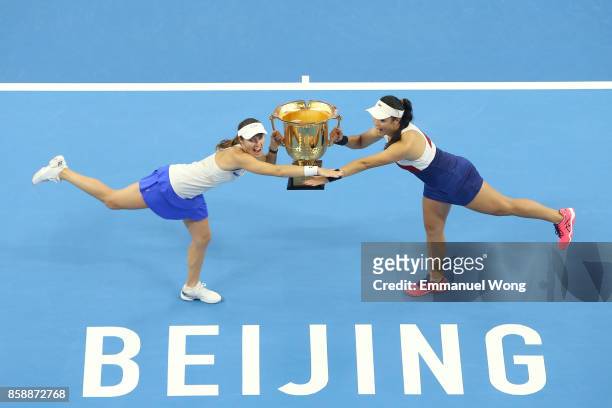 Yung-Jan Chan of Chinese Taipei and Martina Hingis of Switzerland pose with their trophy after winning the Women's doubles final match against Timea...
