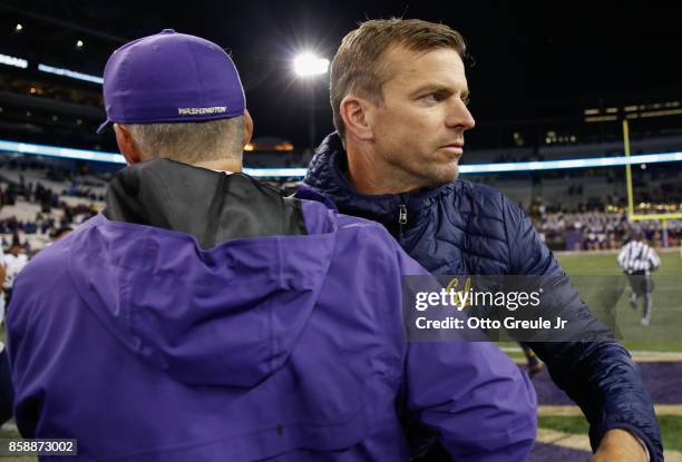 Head coach Chris Petersen of the Washington Huskies is congratulated by head coach Justin Wilcox of the California Golden Bears at Husky Stadium on...