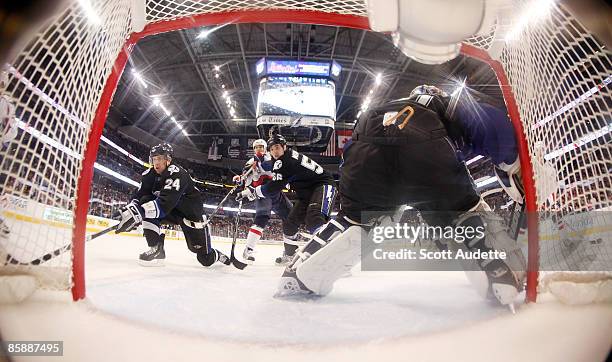 Matt Pettinger and Vladimir Mihalik of the Tampa Bay Lightning chase after the puck as goaltender Karri Ramo defends the goal against the Washington...